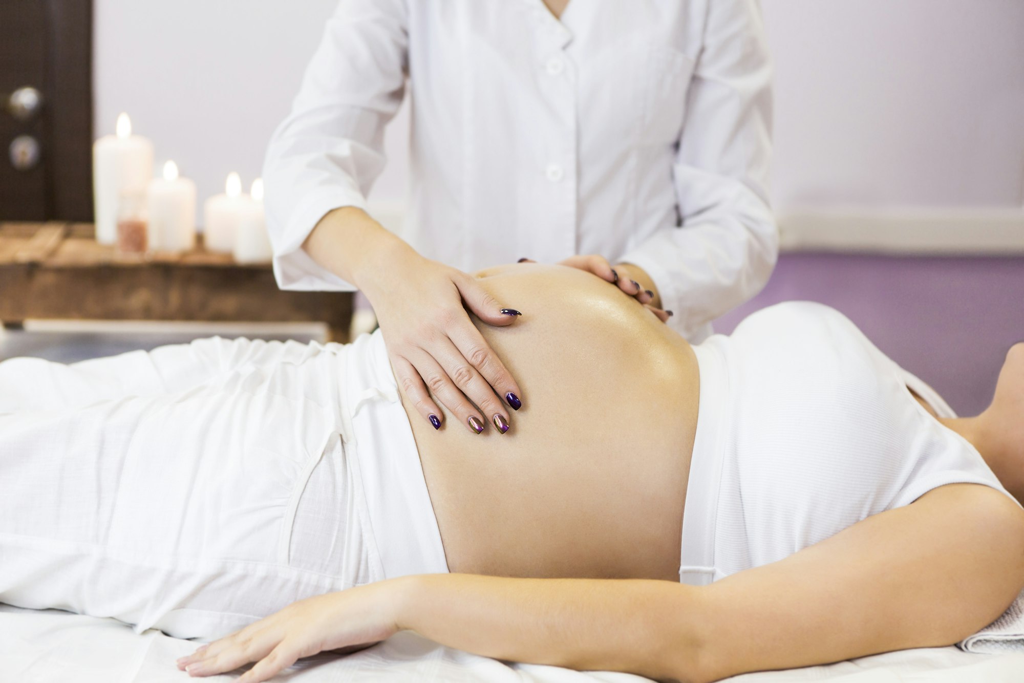 Pregnant woman have massage treatment at spa salon